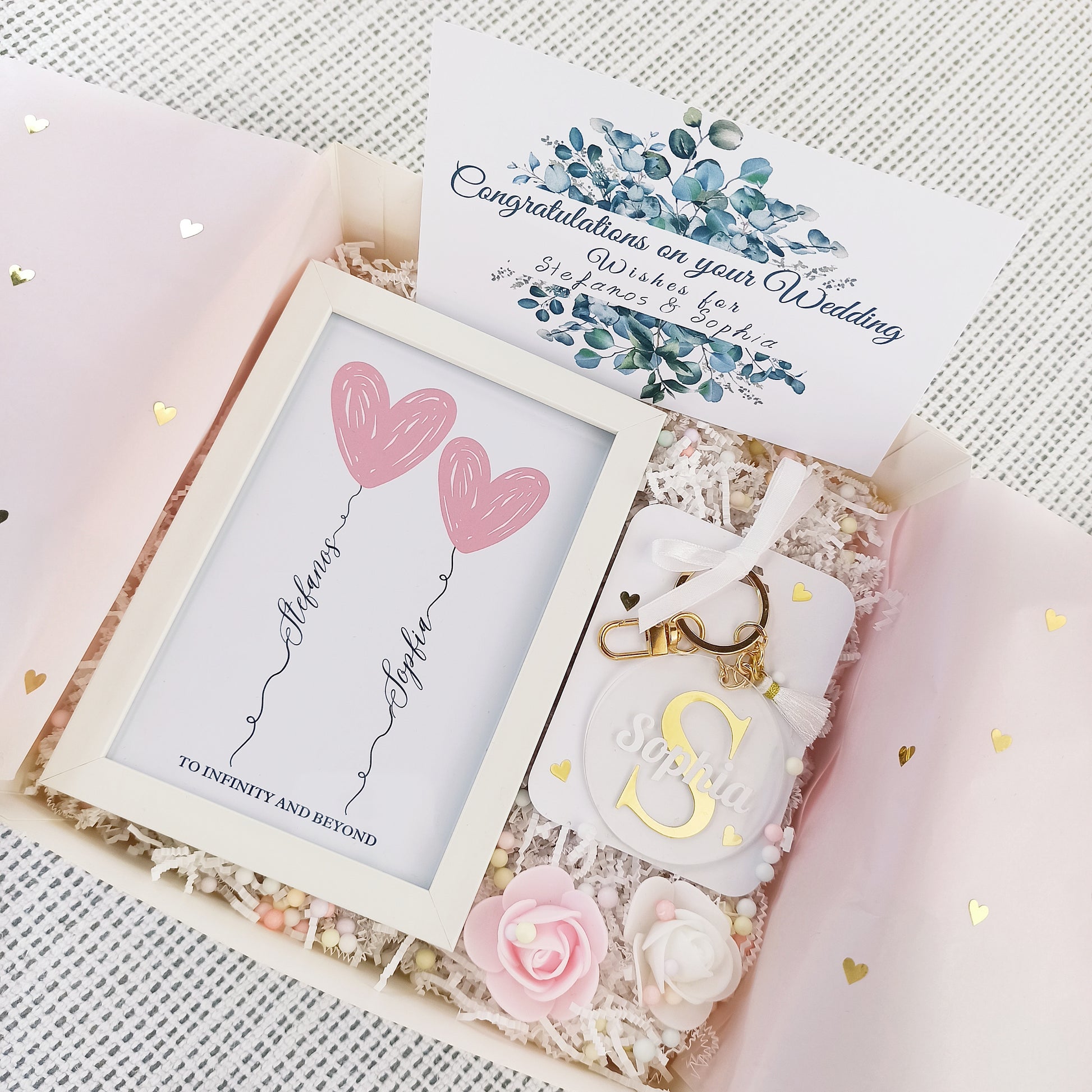 Προσωποποιημένο κουτί δώρου για νύφη που περιλαμβάνει ένα καδράκι με τα ονόματα του ζευγαριού, ένα μπρελόκ με το όνομα της νύφης και μια ευχετήρια κάρτα.